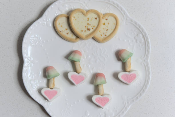 istock Heart-shaped cookies and dessert decorated on white plate, top view 1294240588