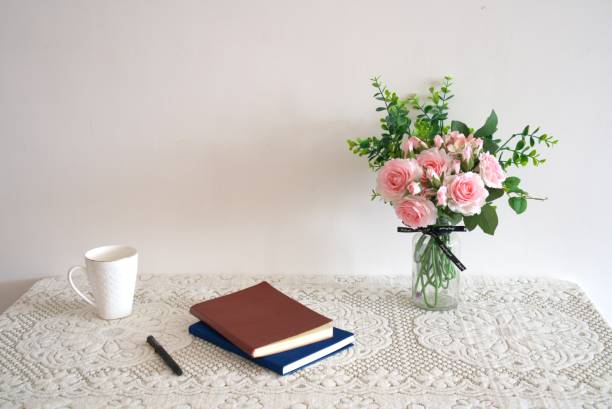 istock Home desk, notebook, green plant, artificial roses bouquet. Workspace with copy space 1294241883