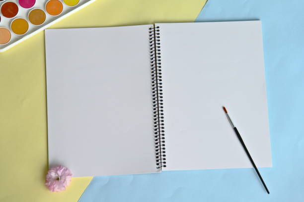 istock Painter's workspace. Top view, office desk with open mockup notebook, paintbrush, color checker 1294242497