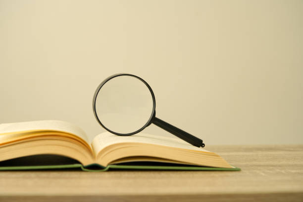 istock Magnifying glass and open book on the desk, education concept, copy space 1294243041