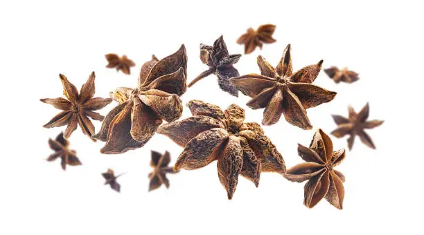 Anise stars levitate on a white background.