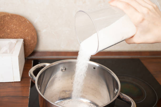 istock women's hands pour sugar into a saucepan, making desserts, cakes, cookies 1294247019