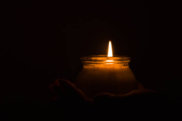 istock Hand holding burning candle in dark, pray for light and peace, religion concept 1294247146
