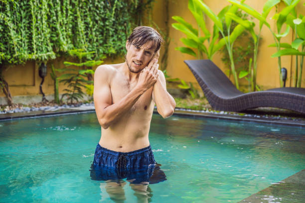 istock Man has an ear ache in the pool. Diver ear 1294252601