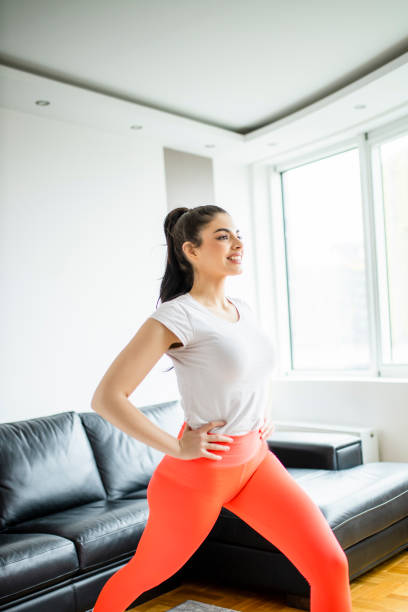 istock Slim beautiful woman doing lunges during home workout 1294253619