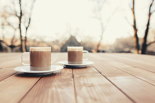 Two cups of coffee in the wooden brown terrace background. High quality photo
