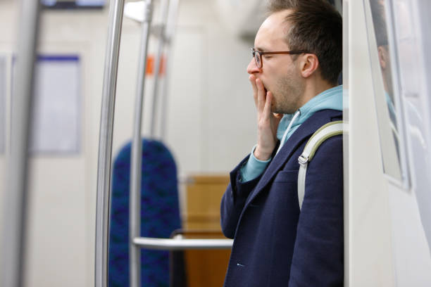 istock Tired exhausted man standing and yawning in subway 1294255977
