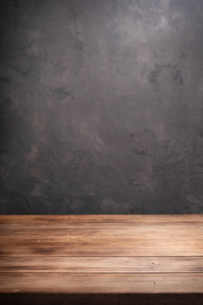 istock wooden desk table or shelf near concrete painted wall background texture surface, front view of tabletop 1294258960