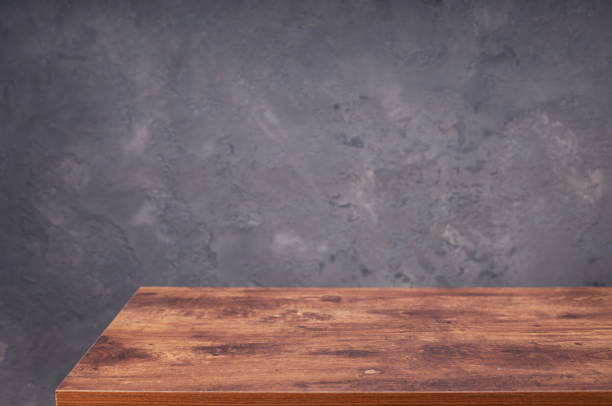 istock wooden desk table or shelf near concrete painted wall background texture surface, front view of tabletop 1294258964