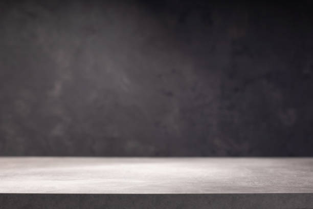 istock wooden desk table or shelf near concrete painted wall background texture surface, front view of tabletop 1294258970