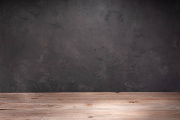 istock wooden desk table or shelf near concrete painted wall background texture surface, front view of tabletop 1294259044