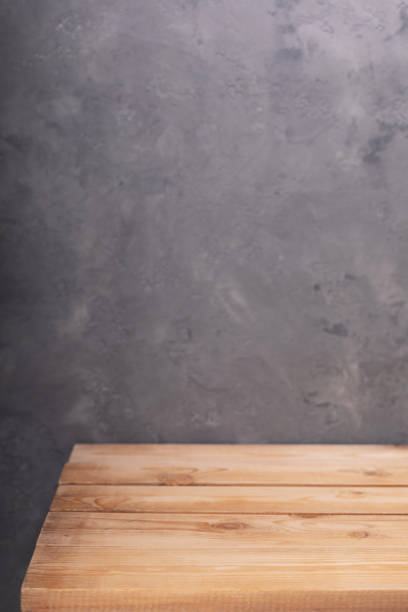 istock wooden desk table or shelf near concrete painted wall background texture surface, front view of tabletop 1294259071