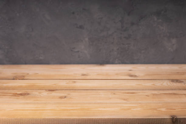 istock wooden desk table or shelf near concrete painted wall background texture surface, front view of tabletop 1294259099