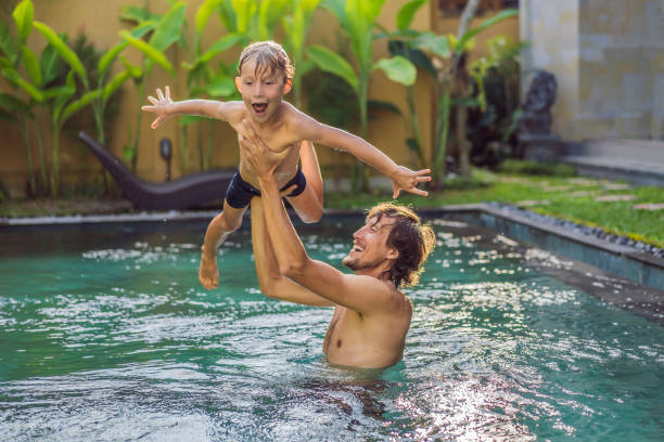 istock Dad and son have fun in the pool 1294259769