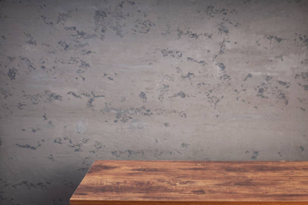 istock wooden desk table or shelf near concrete painted wall background texture surface, front view of tabletop 1294259889