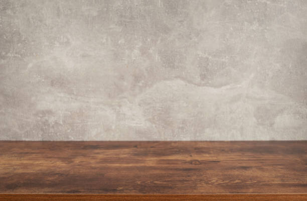 istock wooden desk table or shelf near concrete painted wall background texture surface, front view of tabletop 1294259918