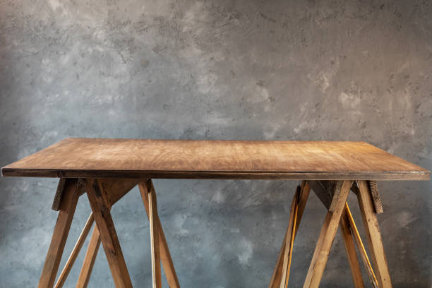 istock wooden desk table or shelf near concrete painted wall background texture surface, front view of tabletop 1294259968