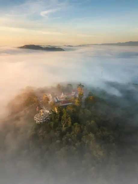 Photo of Aerial view in the morning with sea of fog at The iconic standing Buddha on Wat Phra That Khao Noi one of the most tourist attraction places in Nan province of northern Thailand during the sunrise
