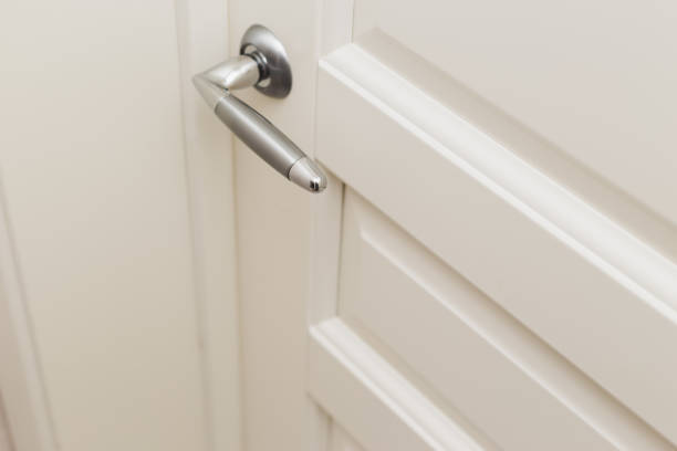 istock Classic white wooden milled door with chrome handle. White Scandinavian interior 1294267341