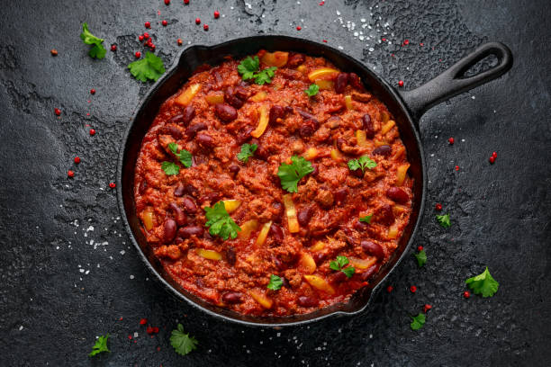 chile picado vegano vegetariano con carne servido en sartén de hierro fundido - salsa de tomate fotos fotografías e imágenes de stock