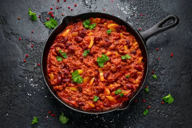 Vegetarian vegan mince chili con carne served in cast iron skillet pan.