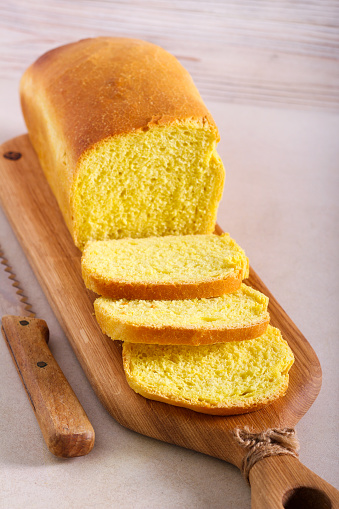 Homemade corn bread loaf, sliced on board