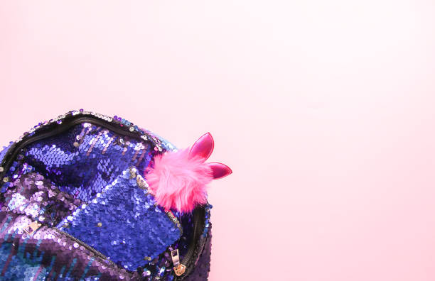 istock Bright composition of fashion accessories. Glitter sequins backpack, notepad and funny decorated pen. Different objects on soft pastel background. Flat lay, top view 1294292522