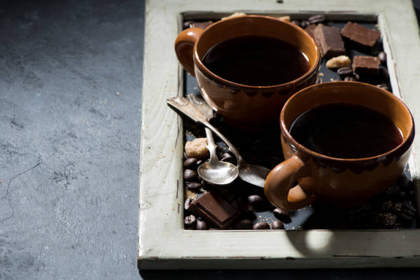 istock fresh black coffee in a cups and chocolate on blackboard 1294293712