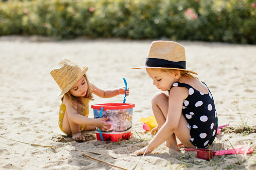 Happy kids are building sandcastle on a beach on a sunny summer day.