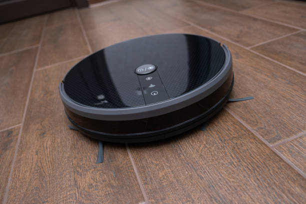 istock Robot vacuum cleaner on a brown laminate close-up 1294302540