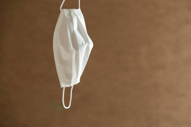 istock Hand holds the mask on a brown background 1294303877