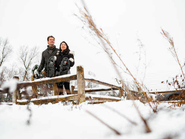 Mixed race couple snowshoeing in winter