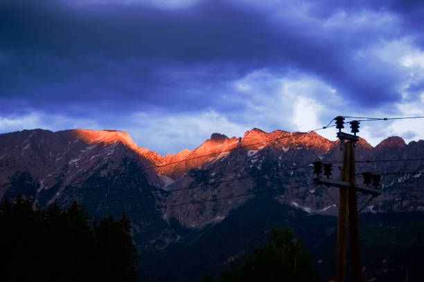 istock glowing mountain peaks in the sunset with rain clouds 1294308609