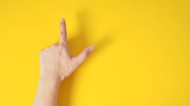 istock Hand is point the finger up hand sign with back hand on yellow background.copy space 1294308766