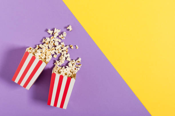 istock Two red striped paper buckets with popcorn top view on color background. 1294309678