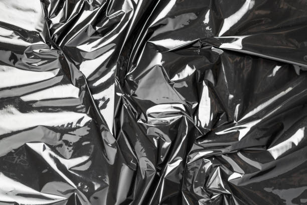 istock Plastic wrap. Black shiny film bag pattern. Transparent dark cellophane texture. Creative crumpled background. 1294310222