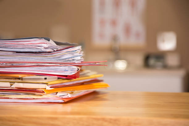 Stack of file folders with documents on a wooden top desk. stock photo