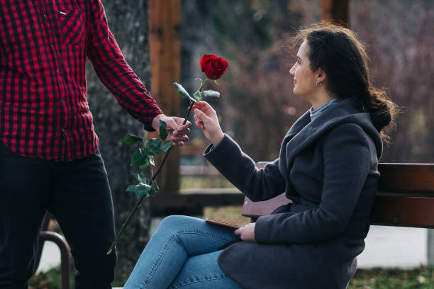 istock Young man gives a red rose to his beloved girlfriend 1294311982