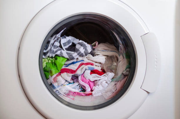 istock Washing machine door with rotating garments inside 1294314737