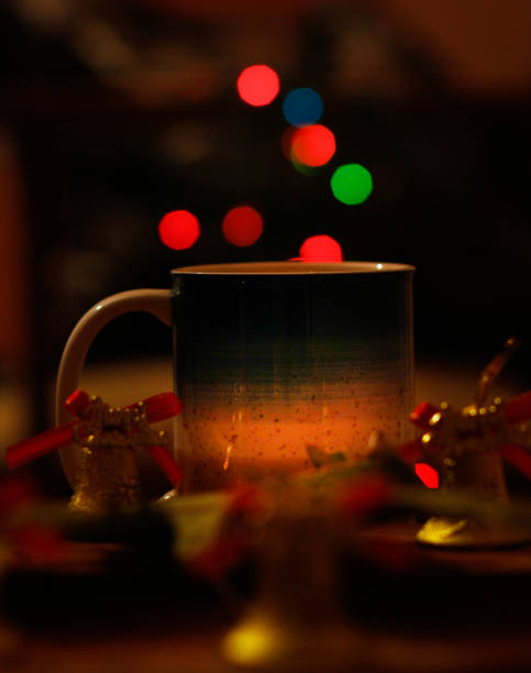 istock Colorful light bokeh and coffee mug on dark background 1294316815