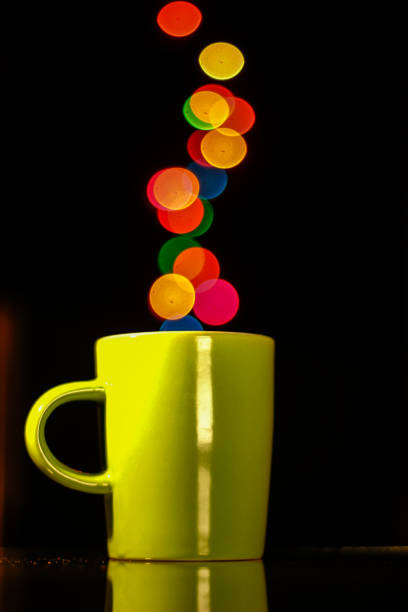 istock Colorful light bokeh and coffee mug on dark background 1294316898