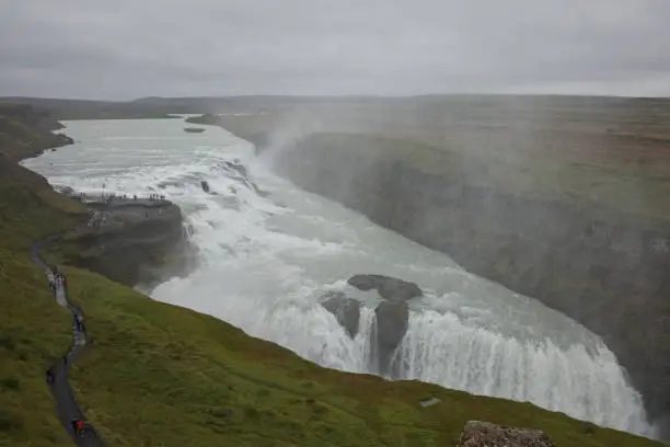 Photo of People visiting and experiencing the power of popular tourist destination - Gullfoss waterfall on Hvita river in Iceland