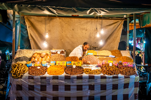 Marrakech, Morocco - January 19, 2018: Street food stall with dried fruits in djemaa el Fna market square, Marrakesh, Morocco