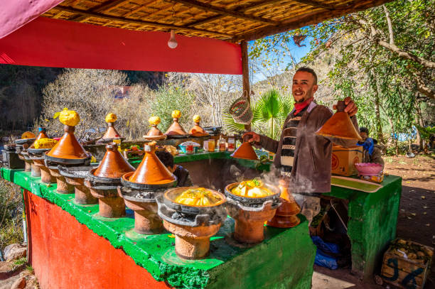 jeune vendeur cuisinant des tajines de poulet dans la vallée d’ourika, maroc - moroccan culture atlas mountains marrakech morocco photos et images de collection