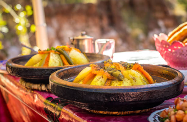 two Traditional Moroccan chicken tajine with chickpeas and vegetables in a hot plate two Traditional Moroccan chicken tajine with chickpeas and vegetables in a hot plate tajine stock pictures, royalty-free photos & images