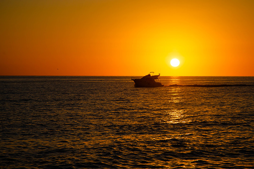 Silhouette of motor boat at sunset on Mediterranean Sea