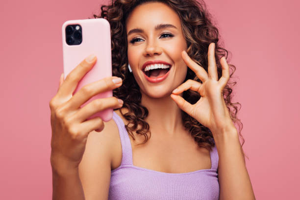 istock Woman in wireless earbuds holding smartphone 1294321626