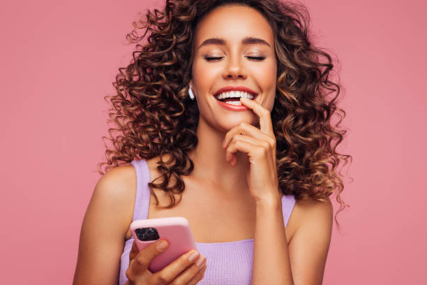 istock Woman in wireless earbuds holding smartphone 1294322143