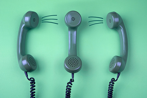 Old rotary telephone handset isolated on green background