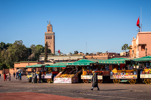 Marrakech, Morocco - January 21, 2018: Food market at Djemaa el Fna Square with Koutoubia Mosque in the background at night, Marrakesh